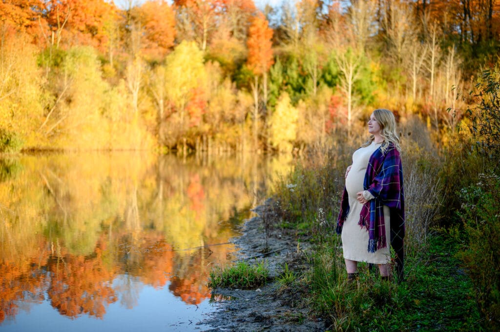 Couple walking through fall leaves at Geo Time Trail in Waterloo during golden hour engagement session