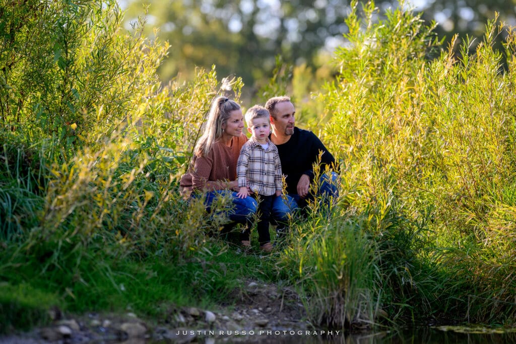 Family standing by the Grand River surrounded by trees and evening light near Scouts Canada trail in Kitchener